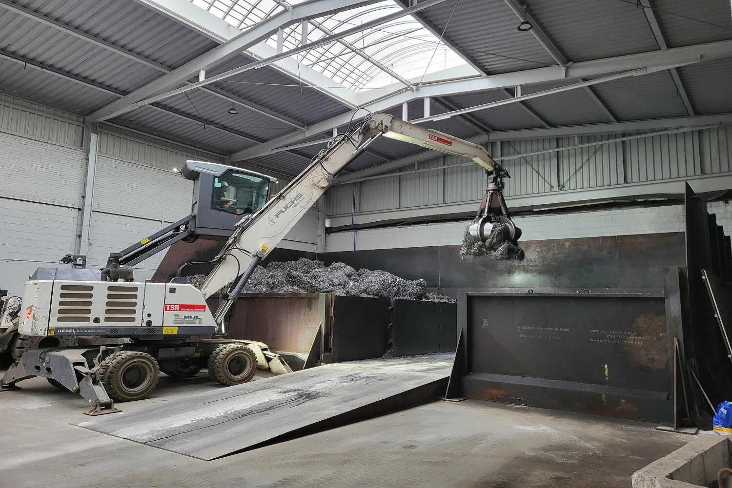 Eine Spänefläche wird von einem Bagger beladen
