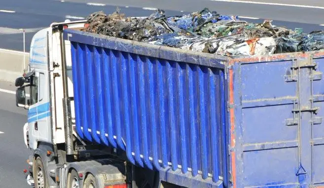 Ein blauer LKW der Altmetall geladen hat