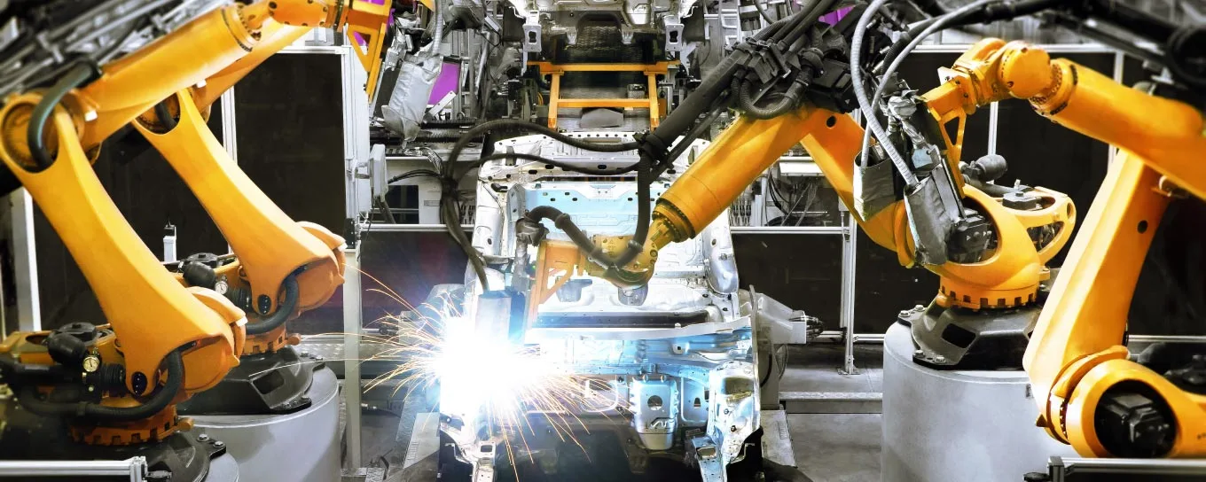 Roboterarme fertigen eine Autokarosse an