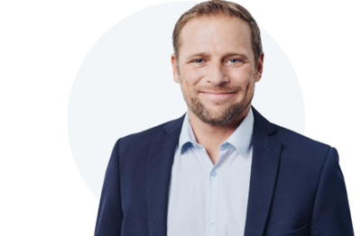 Freundlicher Mann im Anzug lächelt und im Hintergrund ist ein Kreis zu sehen