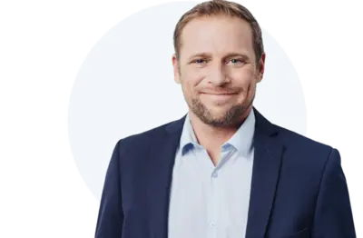 Freundlicher Mann im Anzug lächelt und im Hintergrund ist ein Kreis zu sehen