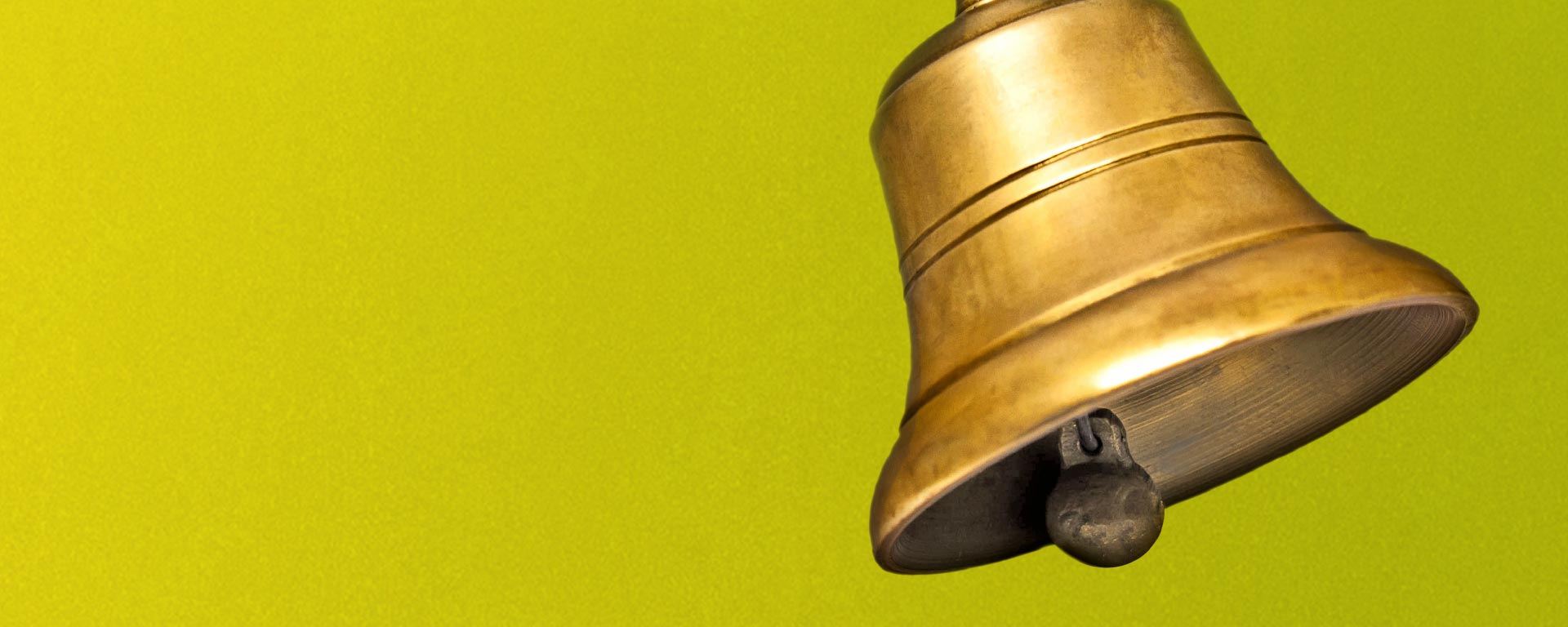 Glocke vor gelbgrünem Hintergrund